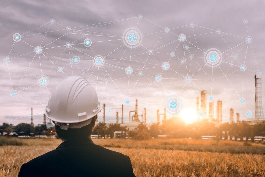 engineering man with safety helmet standing at smart factory background against oil refinery plant in heavy petrochemical industrial estate